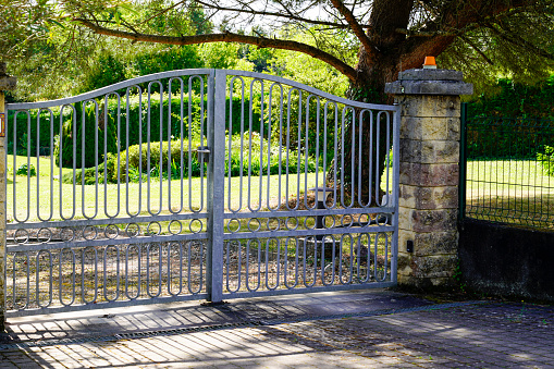 Black ornamented iron gate with walls isolated on white. Clipping path included.