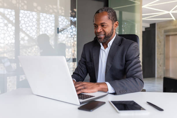 istock Successful mature african american businessman at work inside office, experienced boss working with laptop, man smiling satisfied with achievement results 1665361908