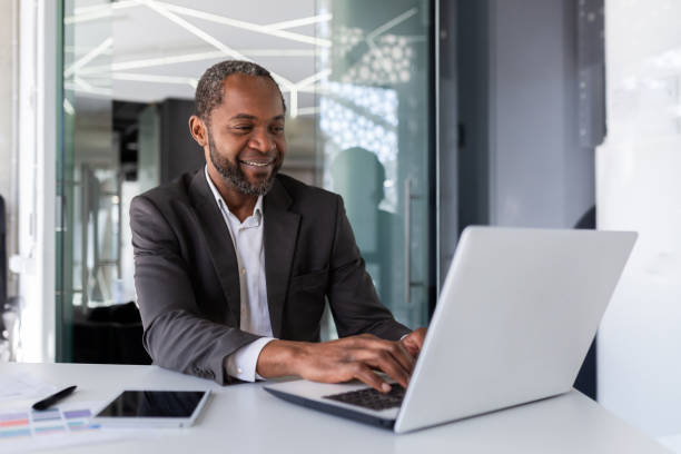 istock Successful mature african american businessman at work inside office, experienced boss working with laptop, man smiling satisfied with achievement results 1665361916