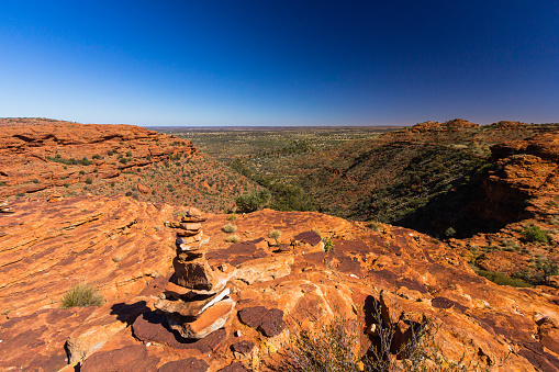 Kings Canyon in Australia features towering sandstone walls, hiking trails, and stunning views. Visitors hike, enjoy sunrise/sunset, and explore its unique landscapes.