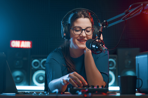 Cheerful female radio DJ hosting a radio show, entertainment and communication concept