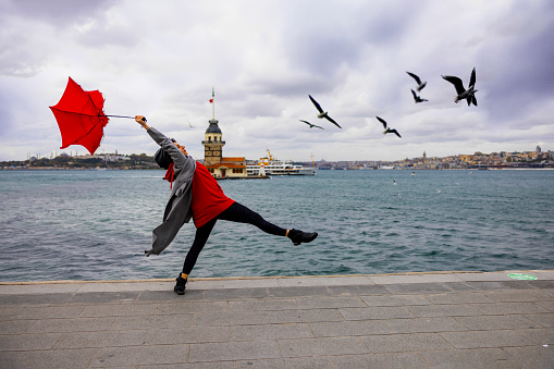 Beautiful woman dancing in front of Maiden's Tower in Istanbul city