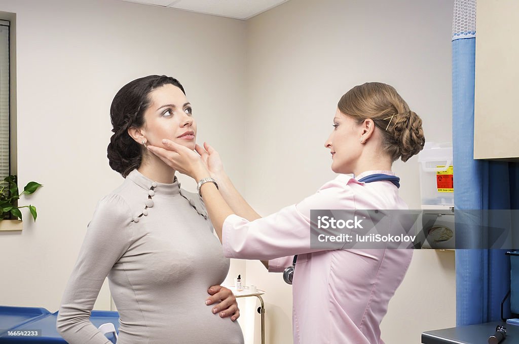 Médico endocrinólogo verificar la tiroides embarazada - Foto de stock de Glándula de tiroides libre de derechos