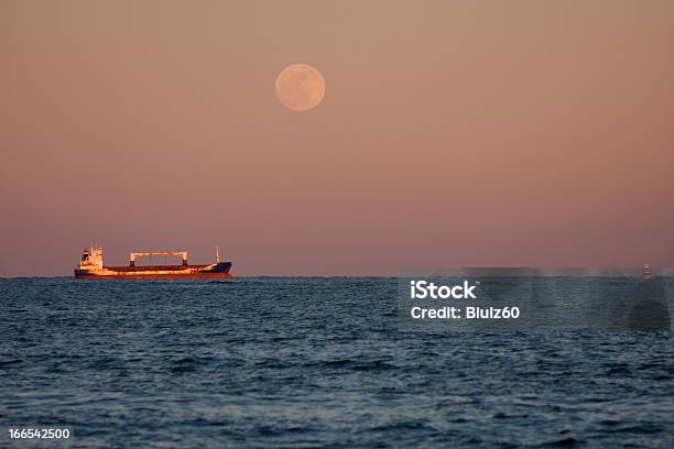 Luna Piena Brilla Di Luce Propria Nave Cargo - Fotografie stock e altre immagini di Acqua - Acqua, Ancorato, Blu