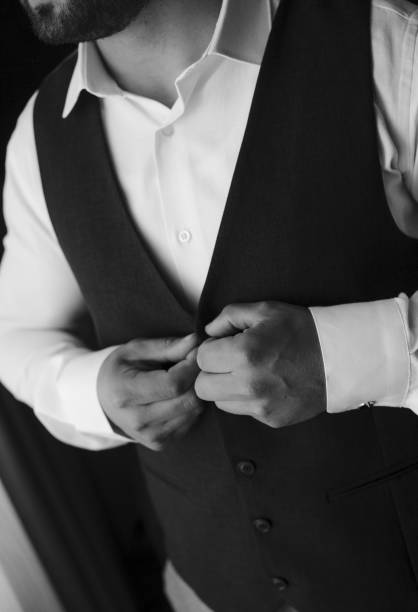 istock Vertical of a groom hearing classic suit in grayscale 1665432938