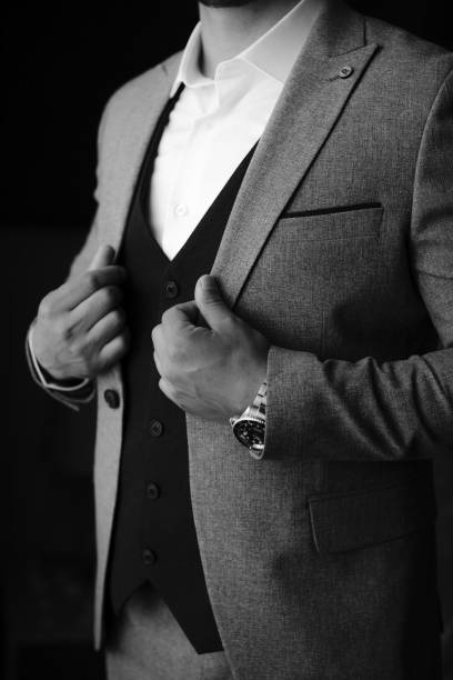 istock Vertical of a groom hearing classic suit in grayscale 1665432939