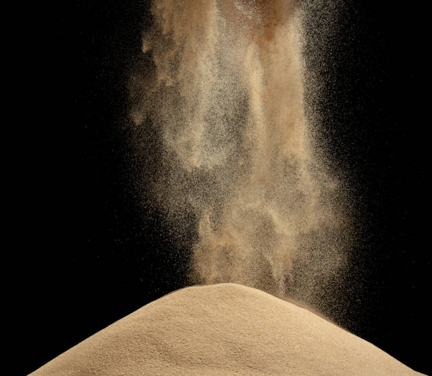 istock Wind blow on sand hill and splash fly in air. Sand dune hill over wind storm and blast dust splash over mountain. Sunshine afternoon on sand hill wind blow. Black background isolated 1665446218