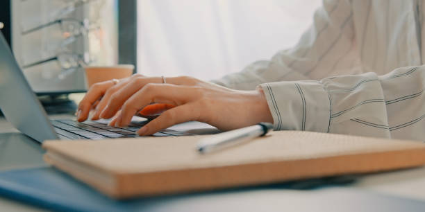 istock Typing email, optometry and hands with a laptop for business, communication or contact on internet. Closeup, table and an employee, secretary or receptionist with a computer for eye care or planning 1665452255