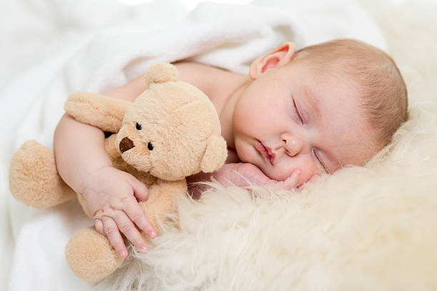 istock newborn baby sleeping on fur bed 166546070