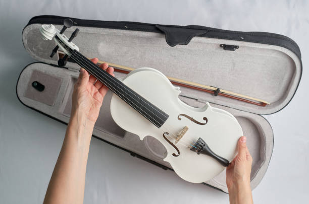 istock A woman's hand takes a white violin out of its case 1665498528