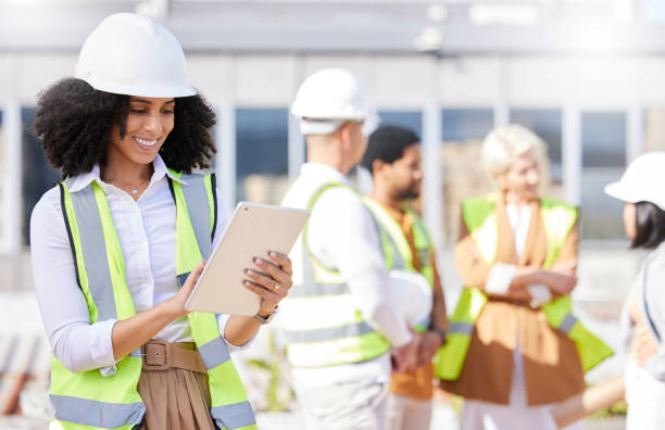 istock Tablet, architecture and a black woman construction worker on a building site with her team in the city. Technology, planning and safety with a female designer reading a blueprint on the internet 1665503592