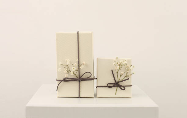 istock Craft gift boxes with flower on light beige wall copy space background. Minimalism style template background. 1665522030