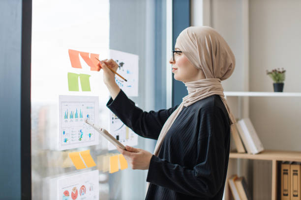 istock Lady with tablet writing notes on stickers near infographics 1665527606