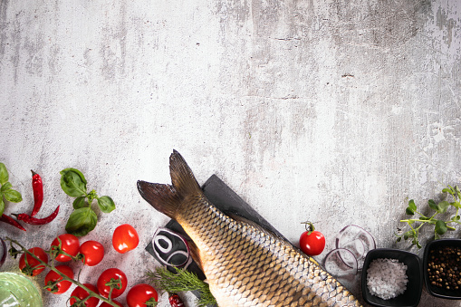 Fresh tasty food fish crucian carp served on old blue wooden table with cooking ingredients. Top view. Copy space