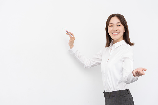 A Japanese woman wearing a white shirt.she is teaching a class.