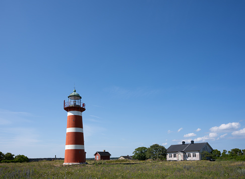 Classic view of famous Lighthouse Dornbusch on the beautiful island Hiddensee with blooming flowers in summer, Baltic Sea, Mecklenburg-Vorpommern, Germany