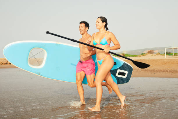 istock Paddle-board entering the water with the board in hand. 1665614964