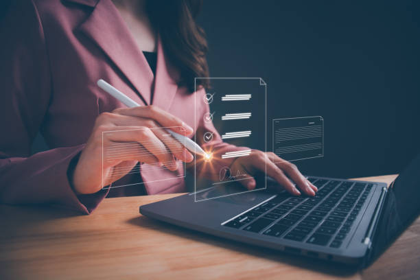 istock Businesswoman working on laptop with electronics document icons by virtual notebook screen using a stylus pen checking list on a digital tablet. E-document management Paperless workplace concept. 1665634146