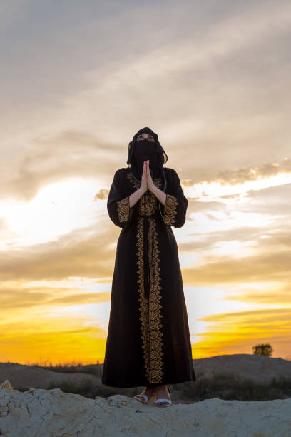 istock An Islamic woman prays while standing on a mountain at sunset. Religious tradition evening prayer 1665649350