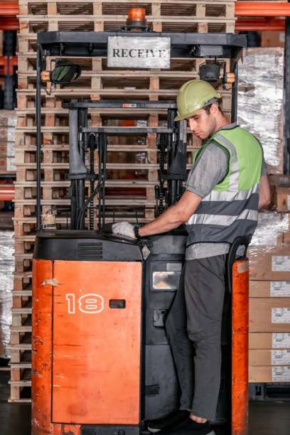 istock Warehouse forklift operator moves, stores merchandise, stays in touch with team, boss via radio 1665651703