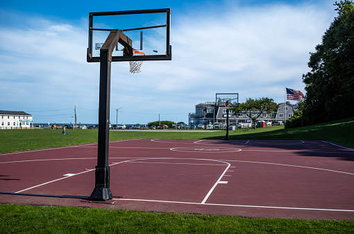 Anempty basketball court located at the park in Falmouth Heights, Falmouth, MA on Cape Cod.  Often busy with people, this park leads directlynto the Vineyard Sound.