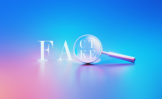 Metallic magnifier and Fact- Fake word illuminated by blue and pink lights on blue and pink background. Horizontal composition with copy space.
