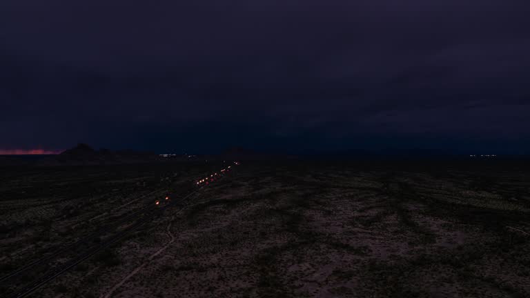 Aerial view of highway in Arizona during thunderstorm on background. Traffic on interstate during sunset with lightning. Fabulous view from drone