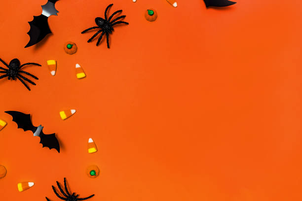 istock Halloween decor on orange background, decorative spiders, bats and candies 1665677789
