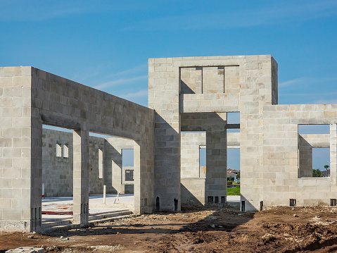 Concrete shell of a single-family house under construction in a suburban residential development on a sunny morning in southwest Florida