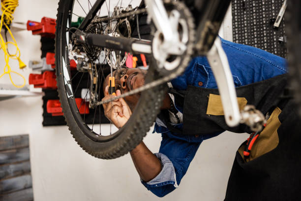 istock Serious bicycle mechanic works in workshop 1665695316