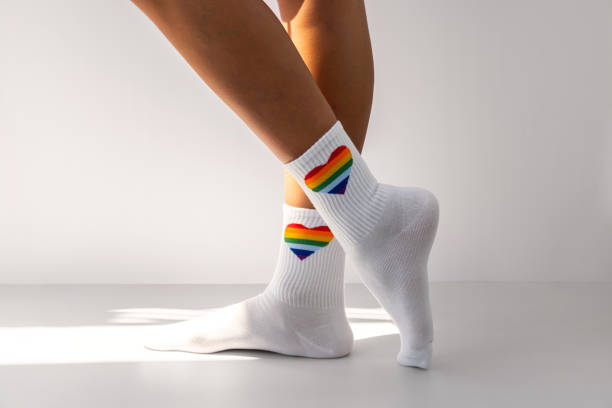 istock Human legs wearing rainbow socks as LGBT flag. 1665700885