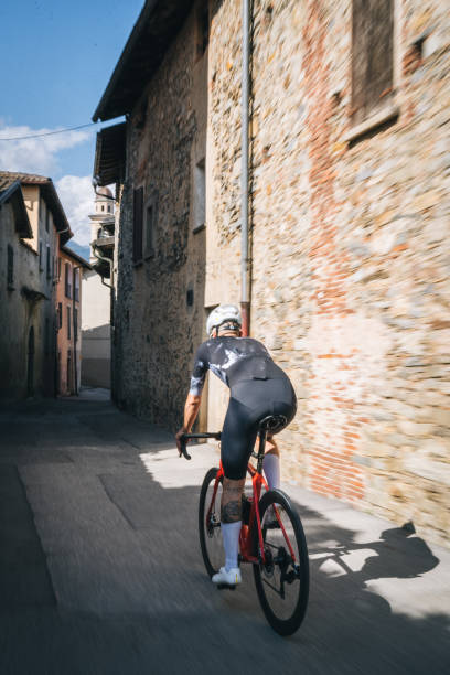 istock Man road bikes through village 1665704136