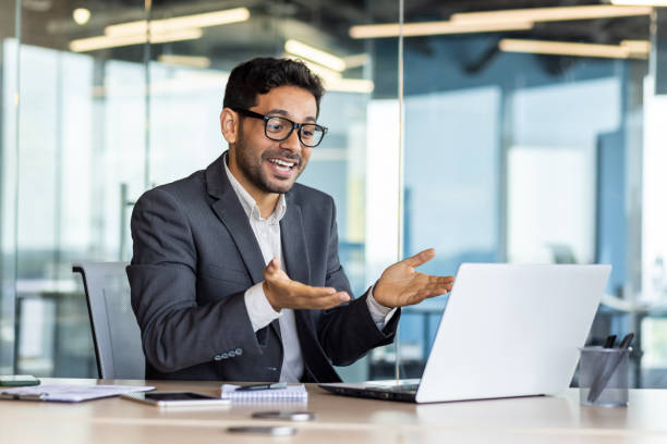 istock Young successful hispanic businessman talking on video call using laptop, man inside office at workplace, online meeting with colleagues and partners 1665704795