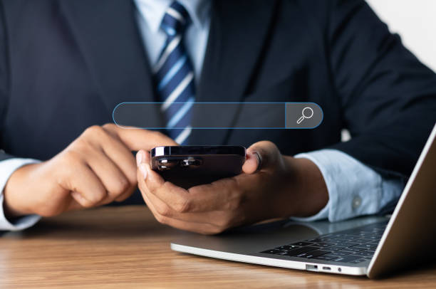istock Searching Browsing Internet Data Information Networking Concept, Businessman use phone and laptop screen a search box for information on the Internet. finding data, Using Search Console with website. 1665716317