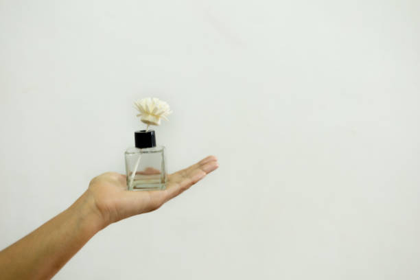 istock A woman's hand is holding a perfume bottle. on a white background 1665716593