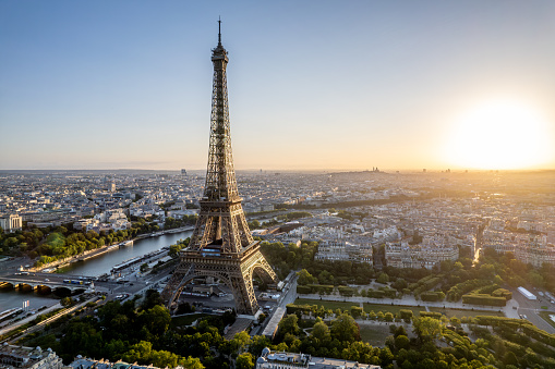 Aerial view of Paris, France, overlooking the famous Eiffel Tower, sunrise in the background.