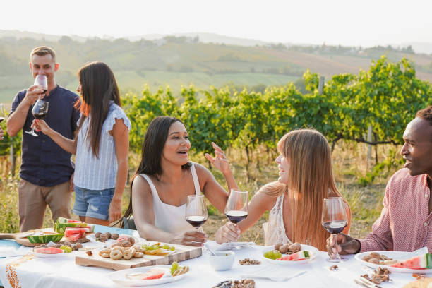 istock Happy multiracial friends having fun together tasting red wine inside vineyard during summer time 1665741930
