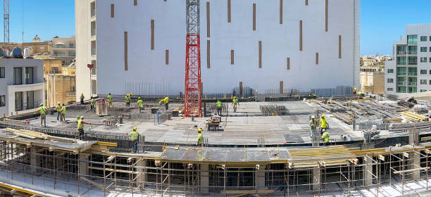 Panoramic view of construction work on the site of a new hotel development in St Julians, Malta St Julians, Malta - 2 August 2023: Panoramic view of construction workers working on the site of a new hotel in the centre of St Julians st julians bay stock pictures, royalty-free photos & images