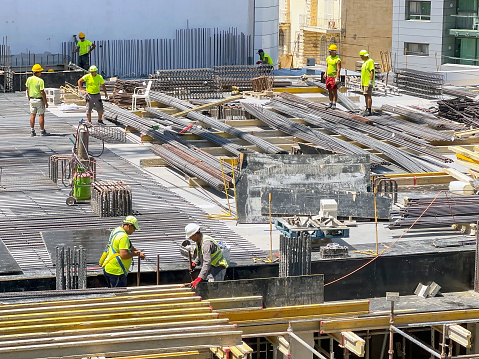 st Julians, Malta - 2 August 2023: Construction workers working on the site of a new hotel in the centre of St Julians