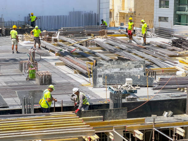 Construction workers on the site of a new hotel development in St Julians, Malta st Julians, Malta - 2 August 2023: Construction workers working on the site of a new hotel in the centre of St Julians st julians bay stock pictures, royalty-free photos & images