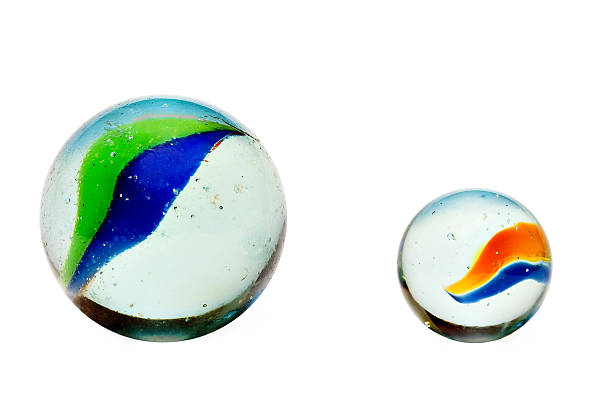Two marbles isolated Two glass marbles, one larger than the other, sid by side, isolated on white. marbles in a row toy childhood stock pictures, royalty-free photos & images