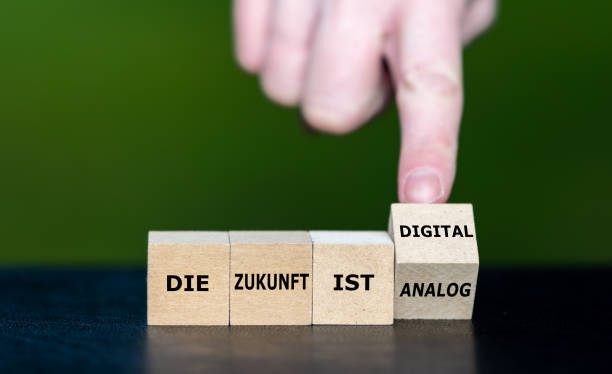 istock Symbol for a digital future. Hand turns wooden cubes and changes the German expression 'die Zunkunft ist analog' to 'die Zukunft ist digital' (the future is digital). 1665774473