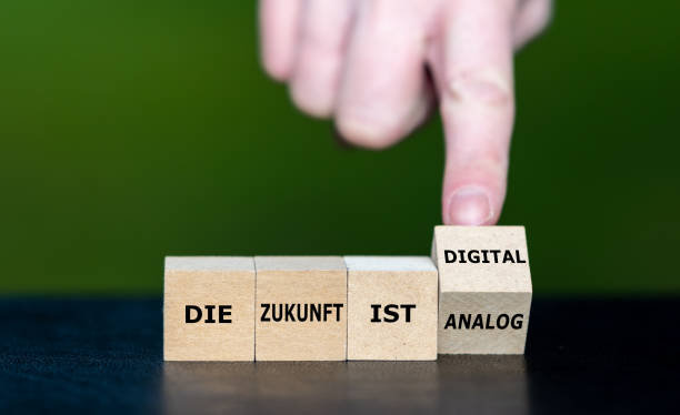 Symbol for a digital future. Hand turns wooden cubes and changes the German expression 'die Zunkunft ist analog' to 'die Zukunft ist digital' (the future is digital). Symbol for a digital future. Hand turns wooden cubes and changes the German expression 'die Zunkunft ist analog' to 'die Zukunft ist digital' (the future is digital). zukunft stock pictures, royalty-free photos & images