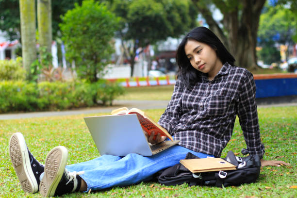 istock bored and tired asian student study reading book and using laptop do homework and preparing examination 1665779022