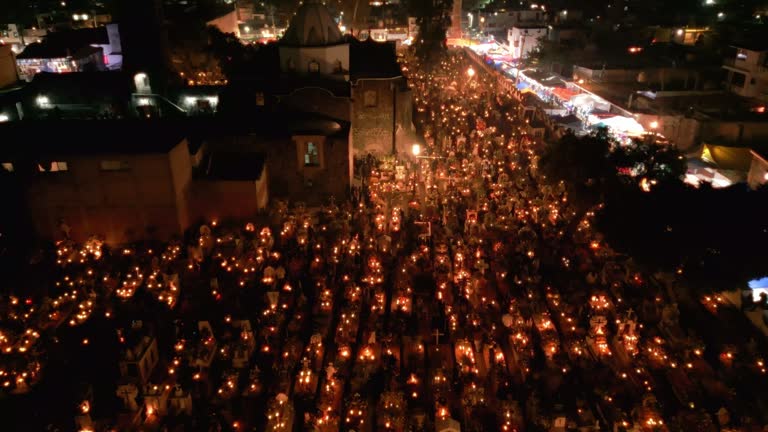 Flying over a well lit cemetery during day of the dead in Mexico