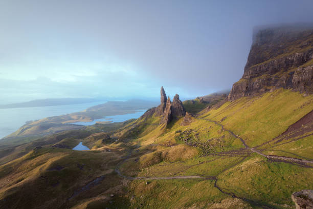 The Old Man of Storr lit by the dawn sun before the rain. stock photo