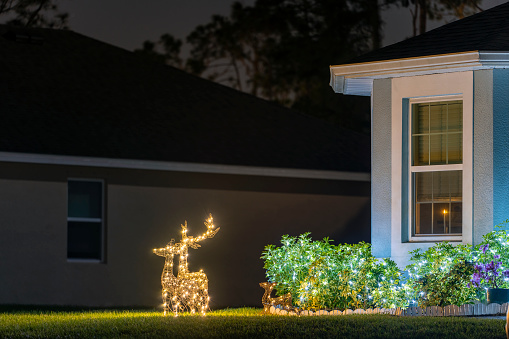 Front yard with brightly illuminated christmas decorations. Outside decor of florida family home for winter holidays.