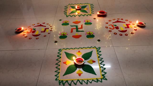 Rangoli design with oil lamp on the floor close up
