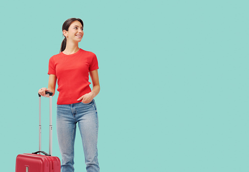 Young tourist woman traveling alone, she is standing and waiting with her luggage, travel and vacations concept