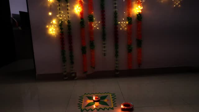Rangoli design with oil lamp on the floor close up
